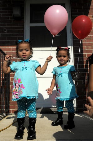 At the groundbreaking of The Musterfield at Concord Place Wednesday morning, twins Aalyiah and Annelise Perez, 2, enjoy the balloons that went along with the ceremonies.