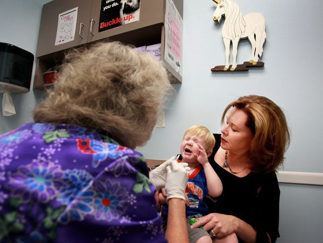 Quinn Malone, 2, the son of Gainesville Mayor Pegeen Harahan, receives one of two doses of the H1N1 Vaccine from registered nurse Beverly Hill at the Alachua County Health Department.