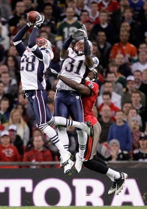 New England Patriots cornerback Darius Butler (28), and safety Brandon Meriweather (31) double team to secure a high ball during an NFL football game against Tampa Bay Buccaneers at Wembley Stadium, London, Sunday Oct. 25, 2009. (AP Photo/Matt Dunham)