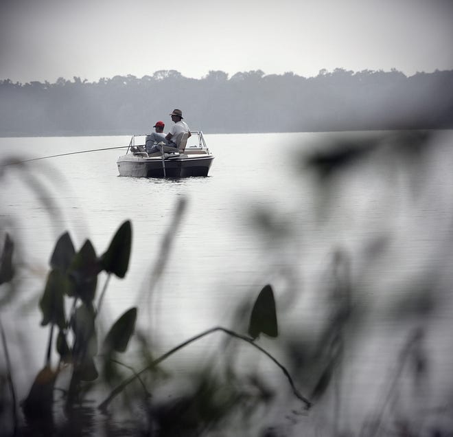 Two fishermen linger near the banks of Palm Point Park on a foggy morning at Newnan's Lake off CR 329B in Alachua County, Fla., Monday, October 26, 2009. The average depth of the 7200-acre lake is only about five feet, but the lake is deepest just off the tip of Palm Point Park.