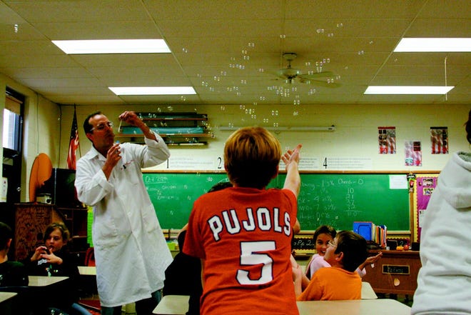 Monmouth College Chemistry Professor Bradley Sturgeon blows bubbles at Lincoln School fifth grade students on Thursday afternoon during some science experiments.