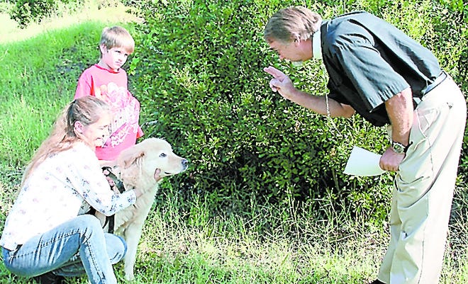 The Rev. Bob Mills blesses Sparky as owner, Lisa Maddox and grandson, Colby proudly approve. Contributed photo