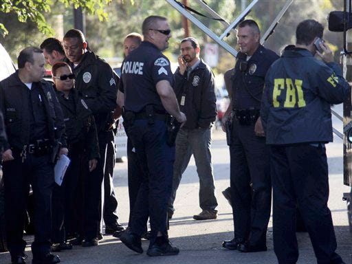 Law enforcement offiicials huddle at the scene in Los Angeles where a gunman shot and wounded two men in the parking garage of a North Hollywood synagogue early Thursday, Oct. 29, 2009. Jewish schools and temples were put on alert in case it was not a lone attack, authorites said.