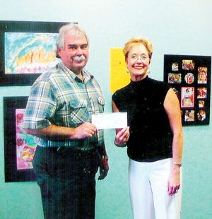 Steve Gibbs, deputy general manager of Operations for the WSI-Oak Ridge (formerly Wackenhut Services, Inc.) Protective Force, presents Children's Museum Deputy Director Carroll Welch with a check for sponsorship of the Children's Museum Gala on Dec. 4.