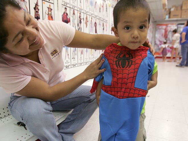 Liliana Vazquez of Houma checks to see if a Spider Man costume fits her son, Geovanny Garcia, 2, Friday at the Ultimate Party store on Martin Luther King Jr. Boulevard in Houma. Vazquez said they are planning to trick-or-treat around their neighborhood tonight.