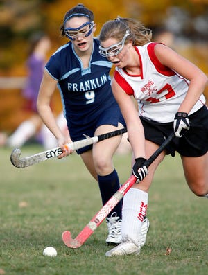 Milford's #17 Blair Smith pushes the ball up past Franklin's #9 Christine Hurley in Friday's game at the Town Park in Milford.