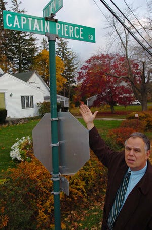 Scituate resident George White points to the street sign honoring an ancestor killed in King Phillip's War in the 17th century. The town is finally correcting the spelling of the name.