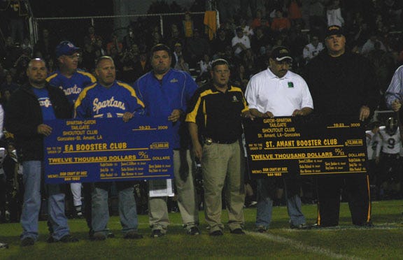 The “Shout Out” committee presents checks in the amount of $12,000 a piece to athletic directors, John Lambert of East Ascension and David Oliver of St. Amant before their football game Oct. 23 after raising funds through the Spartan-Gator?Shoutout and jambalaya dinners.