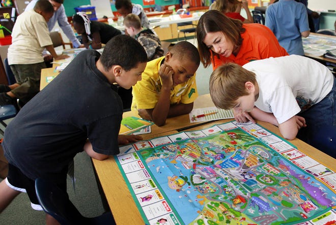 Alachua Elementary School fourth grade teacher Debbie Rudtke helps her students with a math lesson through a game called the Community Game Friday, November 6, 2009. The game teaches kids about real life situations involving finances.