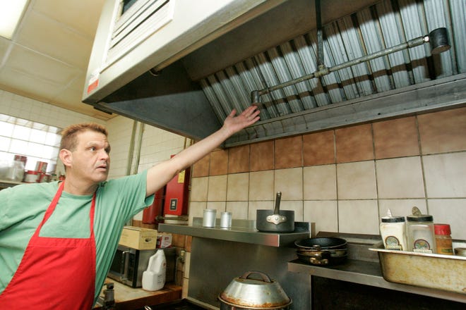 Jimmy Colombi, manager of C.J.'s Lounge, points out the Ansul system, a dry chemical and wet chemical fire extinguishing system, in his lunch kitchen Thursday, Nov. 5, 2009. The business is affected by the new state fire marshal's administration codes, which require commercial kitchens to have the latest in fire suppression equipment over deep-fryers and grills. "We're a bar and grill, and we have to do whatever it takes to survive," Colombi said.