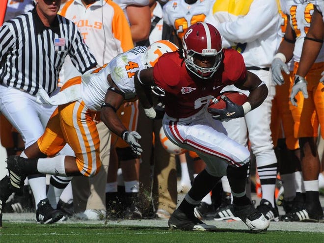 Alabama wide receiver Julio Jones (8) attempts to escape the grasp of Tennessee defensive back Dennis Rogan (41) after making a reception during the first quarter of college football action at Bryant-Denny Stadium in Tuscaloosa, Ala., Saturday, Oct. 24, 2009.