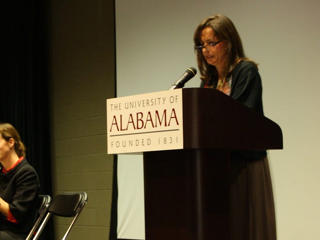 Barbara Fischer, a UA German professor, introduces panel members Friday night during a discussion of the fall of the Berlin Wall.