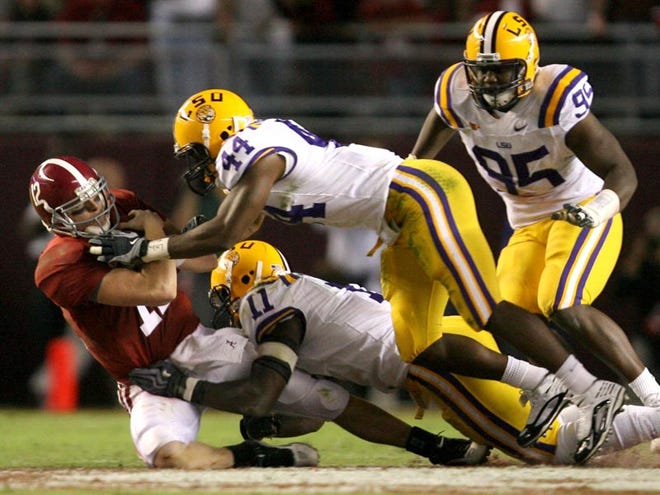 University of Alabama quarterback Greg McElroy (12) is brought down by LSU safety Danny McCray (44) and linebacker Kelvin Sheppard (11) on a quarterback keeper in the third quarter Saturday. Alabama beat the Tigers, 24-15.