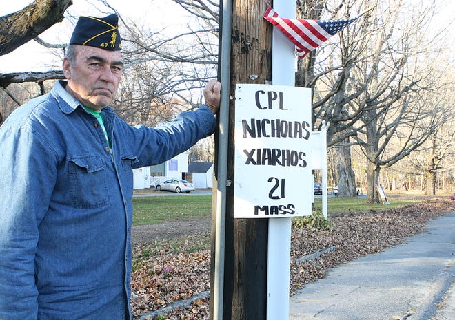 Holliston resident Bobby Blair, a Vietnam veteran, shows a memorial placard for Cpl. Nicholas Xiarhos, a 21-year-old Yarmouth resident killed in Afghanistan in July. Blair's nephew was Xiarhos' baseball coach and Blair's sister, who lives in Dennis, also knew Xiarhos. Blair posts placards honoring servicemen and women killed in Iraq and Afghanistan twice a year, for Memorial Day and Veterans Day.