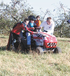 Gunnar Ingram, left, and Ken Carpenter, right, push Luke Giancola down a hill behind the Quincy Ox Roast during a race at the Boy Scout Camporee Saturday.