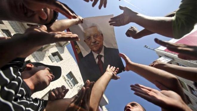 Palestinian supporters of the ruling Fatah party chant slogans as they hold a picture of Palestinian Authority President Mahmoud Abbas during a rally supporting the leader in the West Bank city of Ramallah on Monday.
