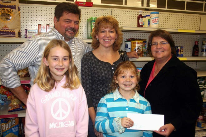 Jon Slack of Union Pallet, wife Twila and Ann Lown of the Branch Area Food Pantry board, with daughter Micki Slack, right, and friend Kira Reichhert, as Slack donated $5,000 to the pantry for the holiday Feed the Needy drive.