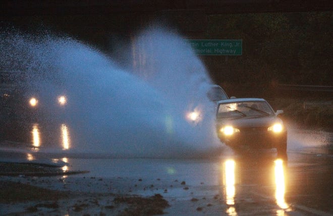 A car hits standing water on the side of South Church Street in Spartanburg early Wednesday morning. Officials have barricaded a portion of the intersection of South Irwin Avenue and South Church Street.