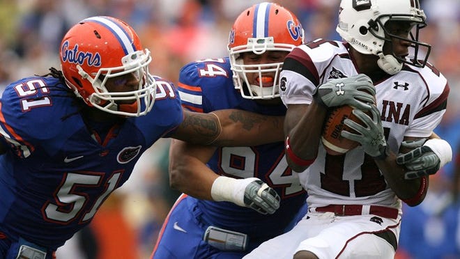 GAINESVILLE, FL - NOVEMBER 15: Linebacker Brandon Spikes #51 and defensive end Justin Trattou #94 of the Florida Gators bring down wide receiver Kenny McKinley #11 of the South Carolina Gamecocks at Ben Hill Griffin Stadium on November 15, 2008 in Gainesville, Florida. (Photo by Doug Benc/Getty Images) *** Local Caption *** Brandon Spikes;Justin Trattou;Kenny McKinley ORG XMIT: 83180006