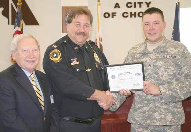 Police Chief Jim Dison, center, accepts the Patriotic Employer Award from Army Reserve Sgt. Gene DeValkenaere, right. At left is ESGR military liaison Bob Schwieder.