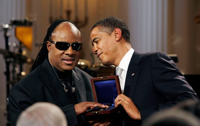 President Barack Obama presents Stevie Wonder, left, with the Library of Congress Gershwin Award during a tribute to Wonder in the East Room of the White House in Washington. The event was comprised of Tony Bennett, Martina McBride and Wonder himself.