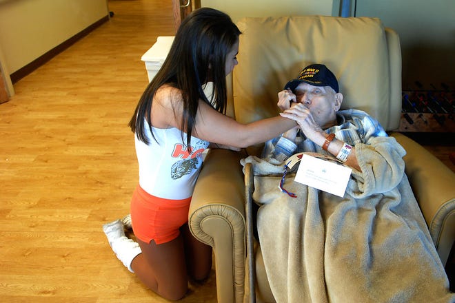 World War II Army Veteran Tony Dolahite gives Ashley Matchett a kiss on the hand after visiting with her at the VA Hospital. George Stone arranged for two girls from the local Hooters restaurant to visit the VA Hospital Thursday.