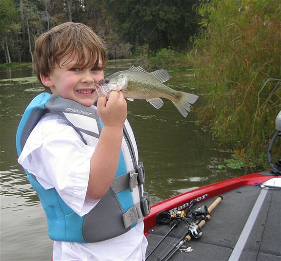 Sammy Bourque learns the catch and release principle of bass fishing from his dad Bryan and paw paw Mike Kling as he prepares to let this one go.