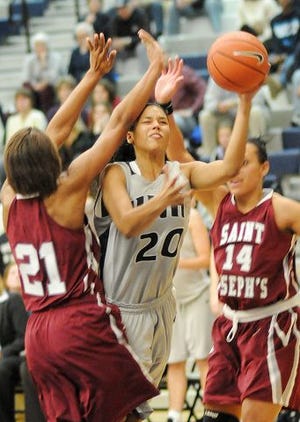 UNH's Candace Williams drives through St. Joseph's defenders Brittany Ford, left, and Dominique Bryant Friday night.