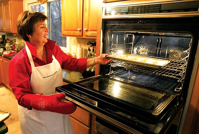 Original: Photo by Amy Paterson/New Jersey Herald - Barbara Seelig Brown puts her cream puffs into the oven. After baking, the cream puffs can be stuffed with sweet or savory filling or frozen for the future.
Published: No Published Caption