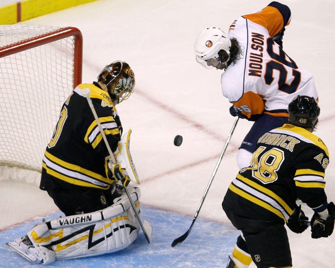 Bruins goalie Tuukka Rask drops to the ice to make a save on a shot by New York Islanders left wing Matt Moulson (26) during the third period. At right is Bruins defenseman Matt Hunwick.