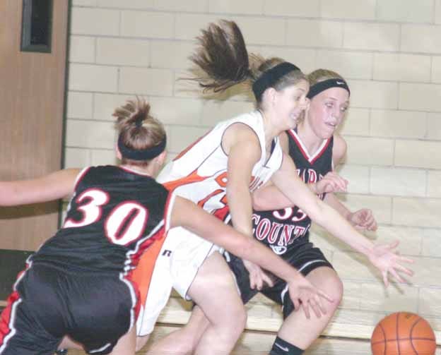 Kewanee’s Tori Forbis, center, scrambles with a pair of Stark County players — Natalie Turner (30) and Brittney Price (35) — for a loose ball during Monday night’s season opener for both squads. The Boiler Girls rallied past the Lady Rebels 55-50.