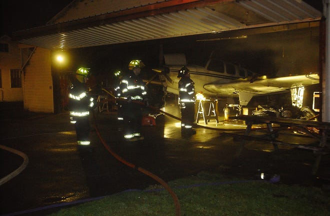 Firefighters extinguish the last of a fire that broke out late Sunday night at a Berkley Airport hangar.