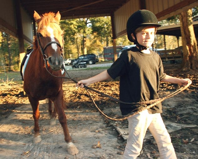 Emily Cardwell leads her pony Jazzy out for an afternoon session at Fairy Tale Equestrian Team in Prairieville.