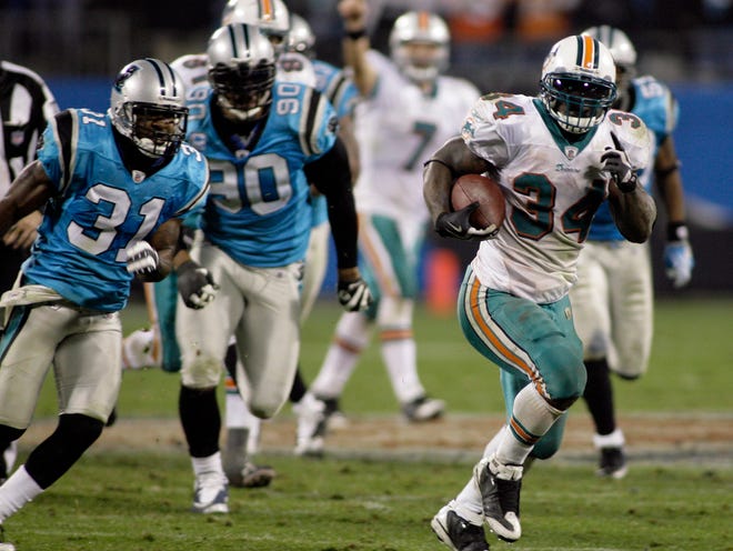 Miami's Ricky Williams (34) runs past Carolina's Richard Marshall (31) and Julius Peppers (90) on a 46-yard touchdown run in the Dolphins' 24-17 victory on Thursday in Charlotte, N.C.