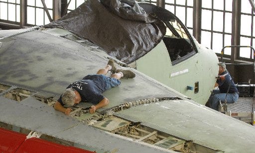 BOB SELF/The Times-UnionBen "Woody" Woodard works on the wing flap of an S-3 in a hangar at Jacksonville Naval Air Station on Tuesday afternoon.