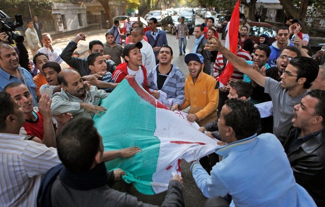 AP Photo/Ben Curtis  Egyptian soccer fans tear-up an Algerian flag before burning it in the street, following overnight violence between Egyptian soccer fans and riot-police, as the fans tried to approach the Algerian embassy in the Zamalek area of Cairo, Egypt, Friday, Nov. 20, 2009. The Egyptian president's elder son called for a tough stand amid an escalating diplomatic row following the loss to Algeria in a World Cup qualification playoff, as angry soccer fans rioted long into the night and early Friday near the Algerian embassy in Cairo.