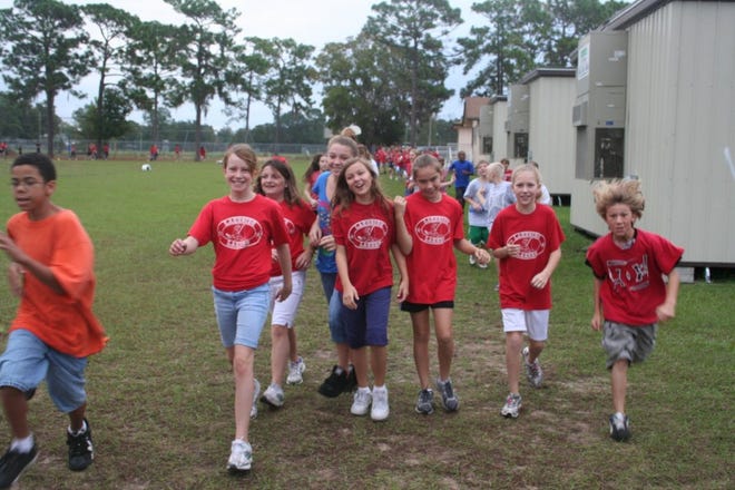 BETH REESE CRAVEY/StaffLakeside Elementary students walk, run and jog on the field behind the campus during Personal Fitness Friday. The program tries to find a fun way to get children focused on their health.