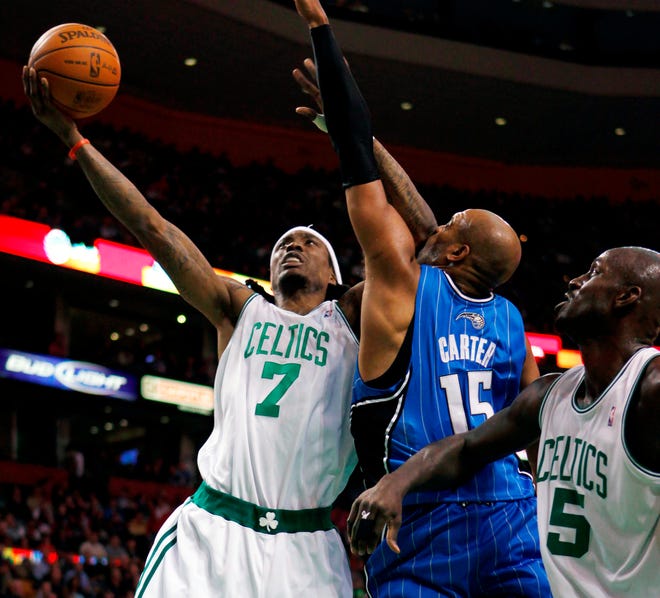 The Celtics' Marquis Daniels (7) drives past Orlando's Vince Carter with teammate Kevin Garnett looking on during last night's game at the TD Garden.