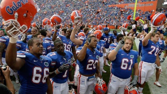 Florida players celebrate and sing the school fight song after defeating Florida International 62-3 in Gainesville, Sat., Nov. 21, 2009.