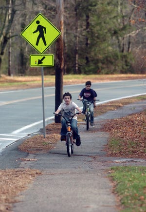 Children ride their bikes on a Spring Street sidewalk in West Bridgewater.