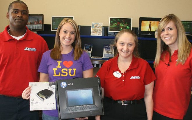 Stacey Fairchild of Gonzales, second from left, shows offer her new Hewlett Packard laptop computer which she won in an Aaron’s Sales and Lease Ownership giveaway drawing at the LSU-Alabama game. Also pictured at the Aaron’s store in Gonzales are, from left, Keon Williams, Sherrie Bergeron and Stacey Usey.