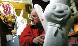 AP Photo/Tim Larsen Macy’s Thanksgiving Day Parade studio vice president John Piper holds a Pillsbury Doughboy balloon model while talking about the process of designing a parade balloon from conception to inflation at the design studio in Hoboken.
