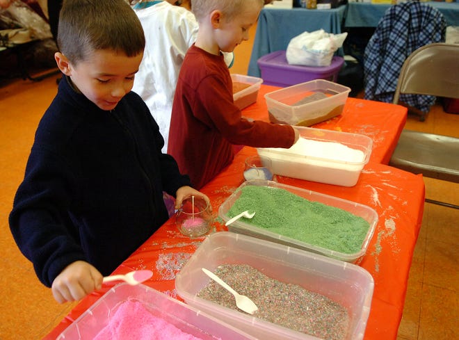 Tommy Fanara, 5, left, and Mike McCabe, 6, make candles at the booth of Amy’s Candles Soaps and Lotions during the holiday craft fair Sunday at the Woodsdale School in Abington.