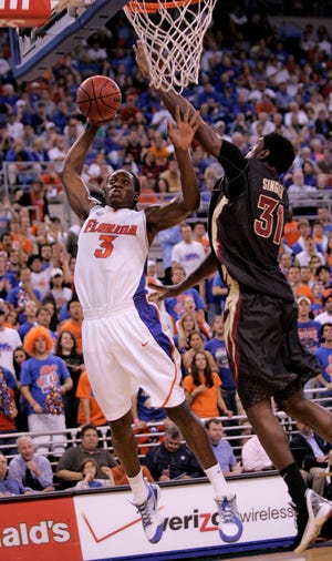 Florida's Ray Shipman, left, goes up for a dunk through the defense of Florida State's Chris Singleton, right, during the first half at the Stephen C. O'Connell Center on Tuesday, November 24, 2009.