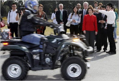 Inez Tenenbaum, chairwoman of the Consumer Product Safety Commission, in red suit, inspects a test drive of a Chinese-made all-terrain vehicle.