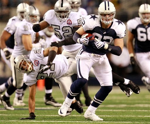 Dallas Cowboys tight end Jason Witten, front, evades a tackle-attempt by Oakland Raiders cornerback Nnamdi Asomugha (21) in the second half of an NFL football game, Thursday, Nov. 26, 2009, in Arlington, Texas. The Cowboys won 24-7.