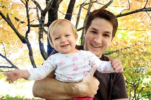 This undated family photo provided Thursday, Nov. 26, 2009, shows John Jones holding his daughter Elizabeth "Lizzie" Dawn Jones. John Jones, 26, of Stansbury Park, died Thursday after he became stuck upside-down in Nutty Putty Cave, a popular spelunking site about 80 miles south of Salt Lake City, Utah.
