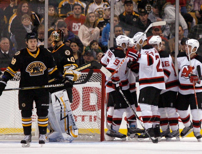 New Jersey Devils' Zach Parise (9) celebrates with teammates after scoring a goal as Boston Bruins goalie Tuukka Rask (40), of Finland, and teammate Matt Hunwick look away during the second period of an NHL hockey game in Boston, Friday, Nov. 27, 2009. (AP Photo/Mary Schwalm)