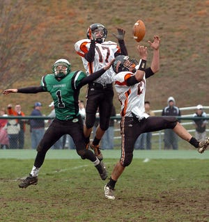 Plainfield's Jeff Buchert, right, catches a pass with teammate Nick Ververis and Griswold's Jordan Robillard Thursday, November 26, 2009 during their game in Griswold.