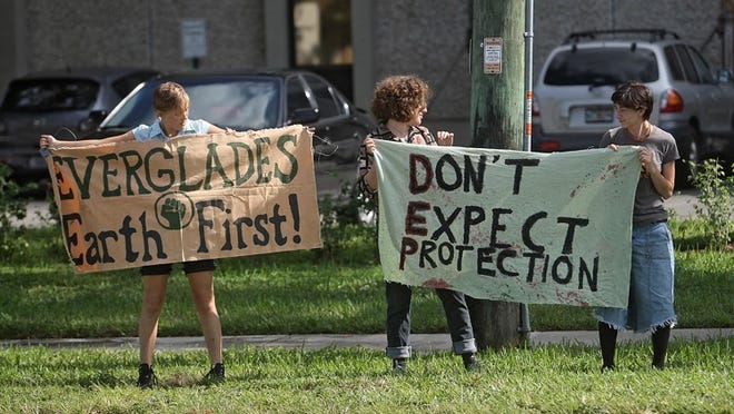 Members of the group Everglades Earth First held a protest outside the Florida Department of Environmental Protection offices Monday afternoon in West Palm Beach.